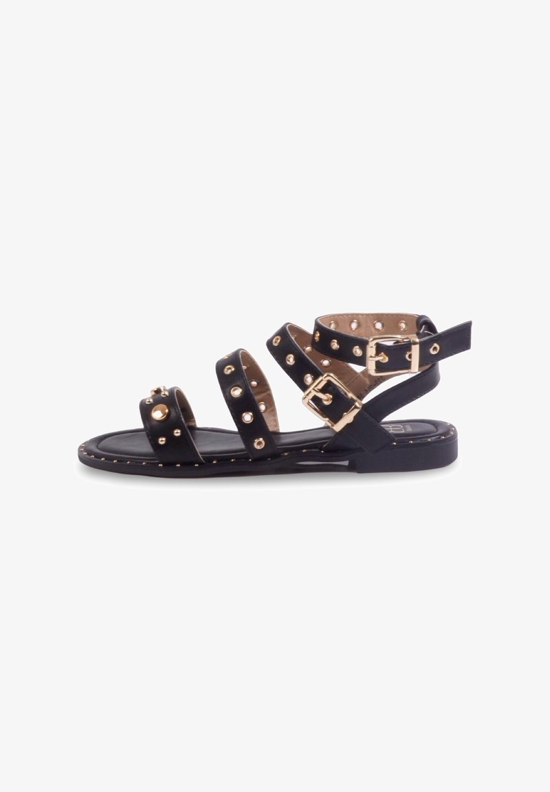 Sandales noires à lanières avec des clous dorés, des boucles et une semelle plate. Comprend plusieurs lanières et des coutures décoratives le long du bord.