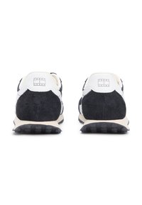 Ασπρόμαυρο αθλητικό παπούτσι με πίσω πάνελ από σουέντ, λευκές δερμάτινες λεπτομέρειες και υφασμένη σόλα από καουτσούκ. Διαθέτει λογότυπο στη φτέρνα.