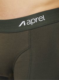 Dunkelgrüne Baumwoll-Boxershorts mit einem weichen elastischen Bund, auf dem der Markenname "aprel" in weißen Buchstaben steht. Glatte Textur und figurbetontes Design.
