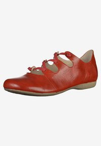 Zapato de cuero rojo con punta redondeada, textura suave y cordones decorativos en el costado. Suela plana con un leve tacón.