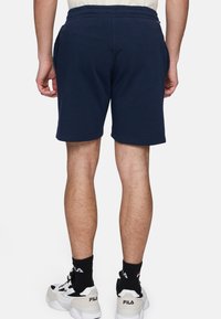 Navyblauwe katoenen shorts met een elastische tailleband, zijzakken en een relaxte pasvorm. Afgewerkt met een soepele textuur en zonder zichtbare patronen.
