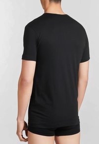 T-shirt nera a maniche corte con scollatura rotonda, in tessuto di cotone morbido e vestibilità rilassata, senza loghi o motivi visibili.
