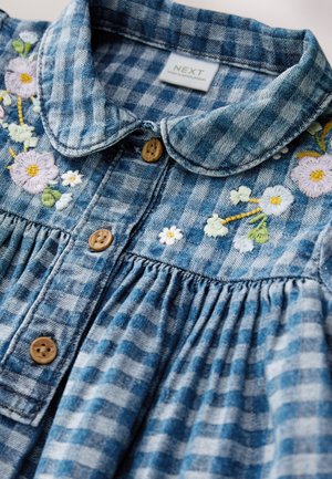 Denim-mekko, jossa sinivalkoinen ruudullinen kuvio, pastellivärinen kukkakirjailu, puiset napit ja kaulus.