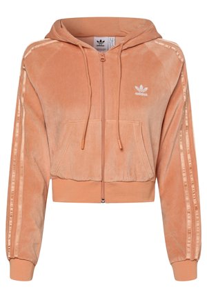 Jasnopomarańczowa welurowa bluza z kapturem i zamkiem, z przednimi kieszeniami, ściągaczami na rękawach i na dole, logo Adidas na piersi oraz trzema paskami na rękawach.