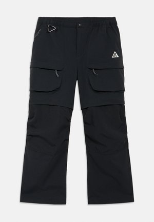 Mustad tööpüksid mitme klapiga taskuga, tõmblukuga tõmbajad, reguleeritav vöökoht ja ACG logo paremal reiel.