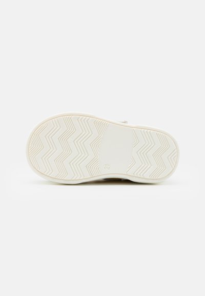 Sole di sneaker in gomma bianca con motivo a zigzag, texture liscia e una sezione centrale rettangolare. Taglia contrassegnata come '21'.