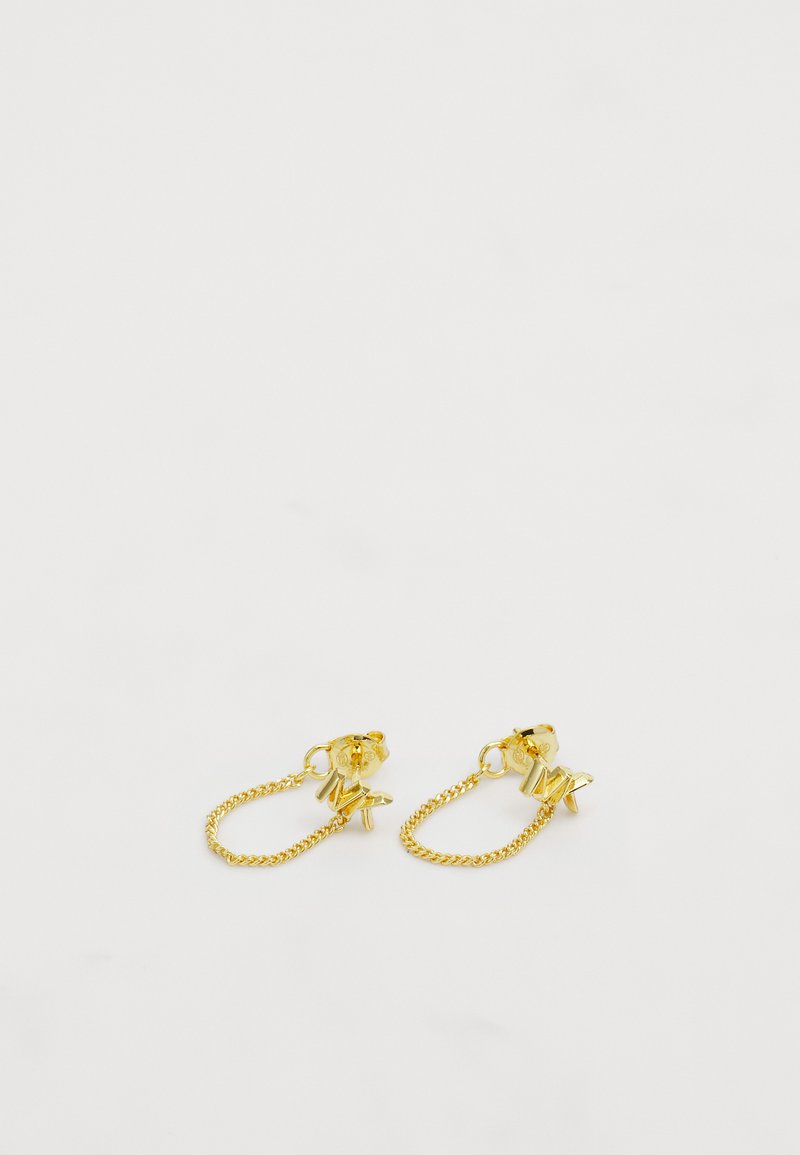 Zelta tonī auskari, kas satur ķēdes savienojumus ar zvaigžņu un burtu piekariņiem. Dizainā ir iekļauts aizmugurējais stiprinājums, lai nodrošinātu drošu valkāšanu.