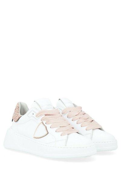 Sneaker bianche in pelle con un dettaglio testurizzato rosa sul tallone e spesse stringhe rosa, caratterizzate da una suola liscia e un design minimalista.