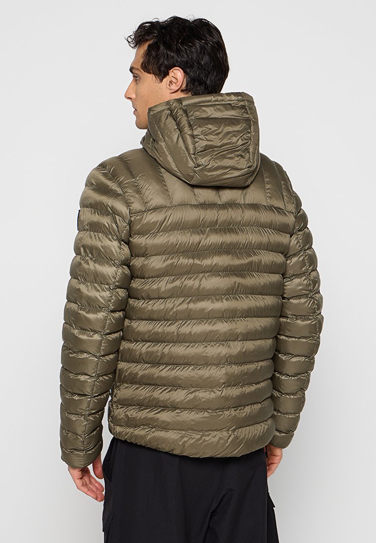 Olivgrüne Steppjacke mit Kapuze, die ein gestepptes Design und eine glänzende Textur aufweist. Zeigt die Rückansicht mit sichtbaren Nähten und Reißverschlüssen.