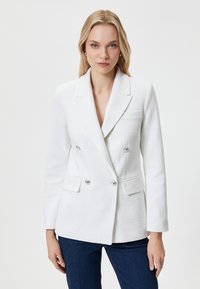 Blazer bianco doppiopetto in tessuto texturizzato, con bottoni argentati, rever a taglio e due tasche frontali. Adatto per abbigliamento formale.