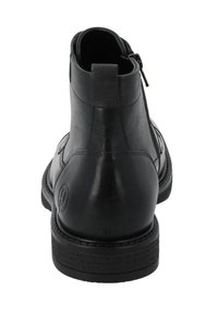 Botín negro de cuero con un diseño elegante, textura suave, cierre de cremallera y suela de goma texturizada. Detalle sutil del logo en el lateral.