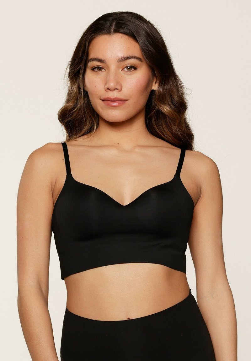 Bralette nera con spalline regolabili, coppe senza cuciture e scollo a V. Texture opaca e design cropped. Senza imbottitura né ferretto.