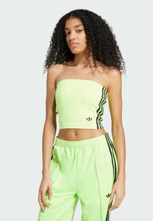 Top corto strapless verde neon con strisce laterali nere e un piccolo logo. Abbinato a pantaloni jogger coordinati con tasche con zip e una vita elasticizzata.