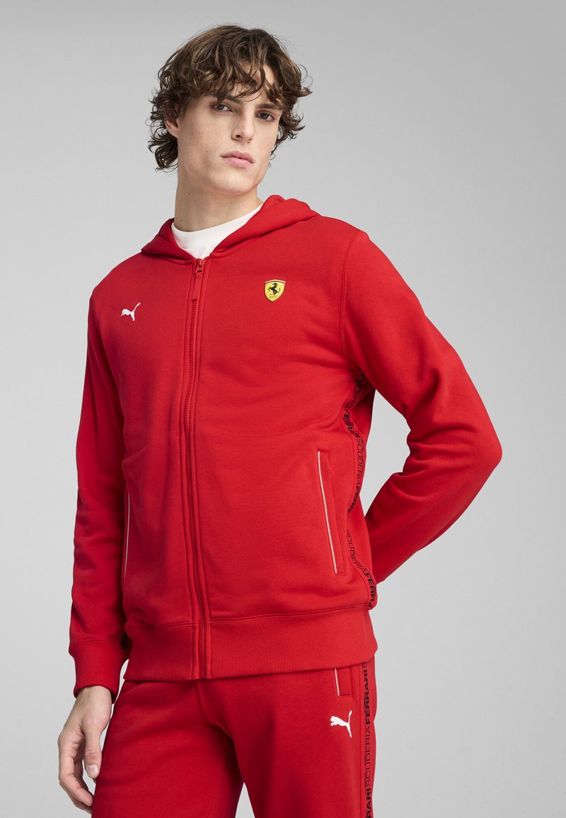 Rød zip-up hoodie lavet af blødt stof, med hætte, to sidelommer, et Ferrari-logo og Puma-emblemet på brystet og på ærmet.