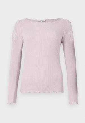 Ljusrosa ribbad långärmad topp med vågformad nederkant och broderade detaljer på axlarna. Slät textur och figurnära design.