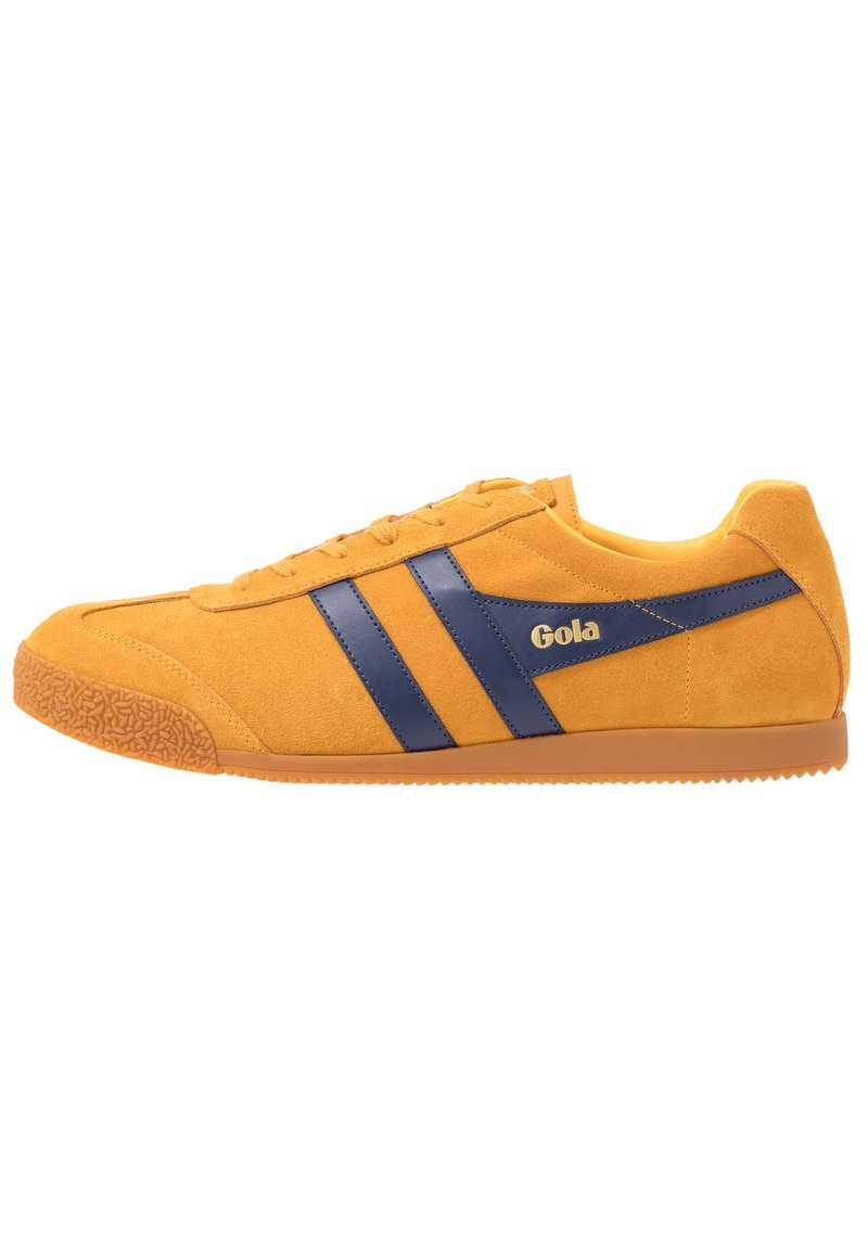 Sneaker giallo in suede con strisce in pelle blu navy, punta rotonda in gomma, suola in gomma con grip testurizzato e dettagli laterali con logo.