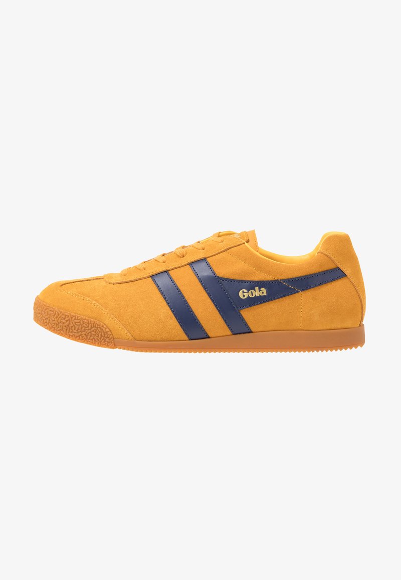 Sneaker giallo in suede con strisce in pelle blu navy, punta rotonda in gomma, suola in gomma con grip testurizzato e dettagli laterali con logo.