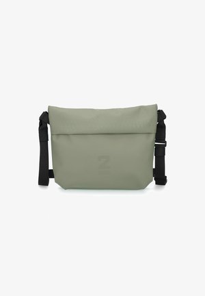 Borsa a tracolla verde chiaro con un'esterno liscio e resistente all'acqua, tracolla nera regolabile e un logo in rilievo discreto sul fronte.