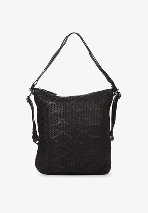 Sac à dos noir texturé avec une surface à motif, doté de bretelles réglables et d'une forme triangulaire, porté par-dessus un blazer gris.