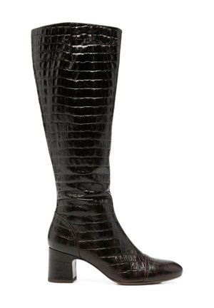 Bota alta de cuero negro con textura de cocodrilo y tacón de bloque de altura media, mostrada desde el lado exterior sobre fondo blanco.