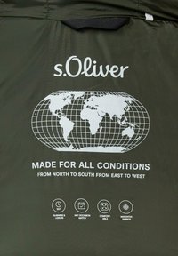 Groen stof met een wit grafisch ontwerp met een wereldkaart en tekst. Bevat pictogrammen voor functies zoals comfort en geschiktheid voor verschillende gelegenheden.