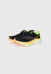 Zapatillas de running negras con parte superior de malla, acentos en verde neón, suela naranja y detalles reflectantes en el logotipo en el costado.