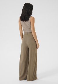 Wide-leg olive green pants made from a lightweight fabric, featuring a high waist, subtle back pockets, and a smooth textured finish.