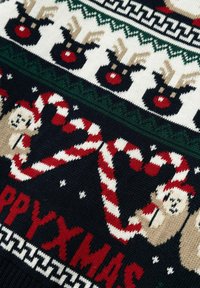 Il maglione a maglia blu navy presenta renne, bastoncini di zucchero e pupazzi di neve in motivi rosso, bianco e verde. Accentuato con "HAPPY XMAS" in bold rosso.