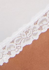 Lingerie bianco realizzato in tessuto liscio, con un delicato bordo in pizzo floreale lungo i bordi. Il pizzo presenta un design a onde per un tocco raffinato.