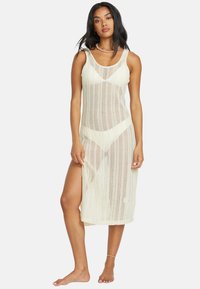 Häkeldress in Off-White, mit Rundhalsausschnitt, seitlichem Schlitz und einem lockeren, leichten Stoff mit offener Struktur.