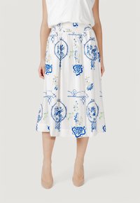 Gonna midi bianca con motivi floreali blu e accenti verde. Presenta un cinturino elastico e una vestibilità ampia, realizzata in tessuto leggero.