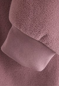 Fleece sweatshirtærme i blødt, struktureret mauve med en ribbet strikmanchet i en matchende nuance. Sammenhængende design uden synlige metaldele.