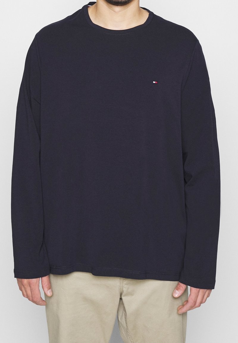 Marinblå långärmad t-shirt i mjuk bomull med rund halsringning, prydd med en liten logotyp på bröstet och en avslappnad passform.