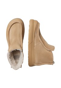 Stivaletti alla caviglia in suede marrone chiaro con una morbida e soffice fodera. Presentano una suola in gomma testurizzata e dettagli cuciti lungo i bordi.