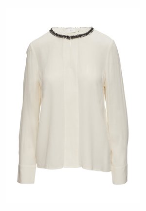 Kremowa bluzka z długim rękawem, wykonana z gładkiego materiału, z czarnym koralikowym wykończeniem wokół okrągłego dekoltu i prostym dołem.