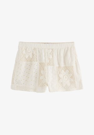 Cremefarbene Baumwollshorts mit elastischem Bund, mit Spitzen-Patches und floralen Lochstickereien verziert.