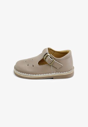 Zapato infantil de cuero beige con correa lateral de hebilla, puntera redonda, recortes decorativos en la parte superior y suela resistente cosida.