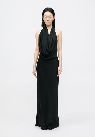 Abito nero con colletto halter, con drappeggio frontale, silhouette lunga e spacco laterale. Realizzato in tessuto morbido e leggero con un design minimalista.
