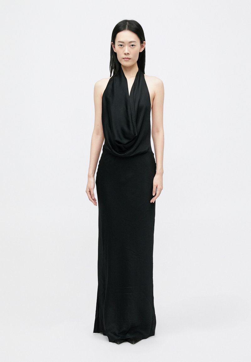 Melna halter stila kleita ar drapētu priekšpusi, garu siluetu un sānu šķēlumu. Izgatavota no gludas, vieglas auduma ar minimālistisku dizainu.