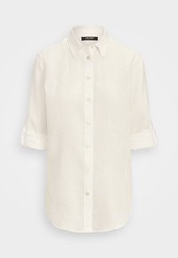 Camisa de lino blanca de manga larga con las mangas arremangadas hasta los codos, cuello clásico y cierre frontal de botones.