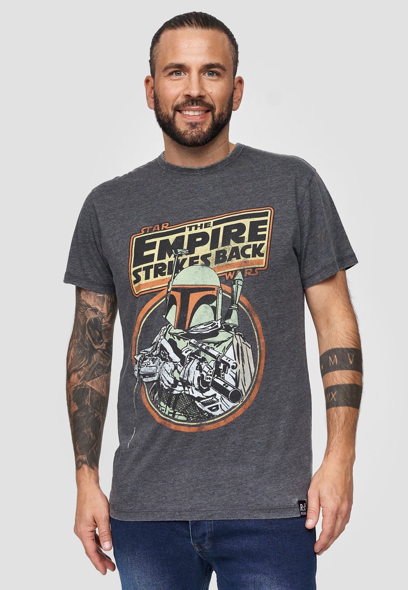 Camiseta de algodón gris con un gráfico vintage de Boba Fett y el texto "El Imperio Contraataca" en amarillo y rojo. Manga corta, cuello redondo.