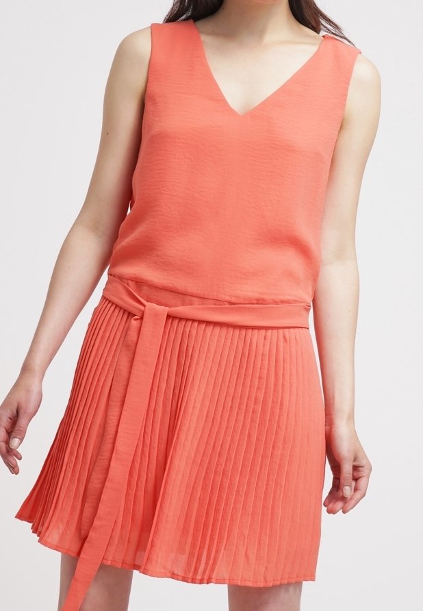 Robe sans manches corail avec un col en V, dotée d'une jupe plissée et d'une ceinture nouée à la taille pour plus de détails et de structure.
