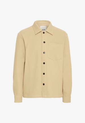 Veste en chemise texturée beige avec col, boutons noirs sur le devant et une poche poitrine. Présente un design simple.