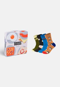 Happy Socks ontbijtgeschenkdoos met vier paar sokken. De sokken zijn voorzien van kleurrijke patronen: mokken, glimlachende gezichten en levendige contrasterende kleuren.