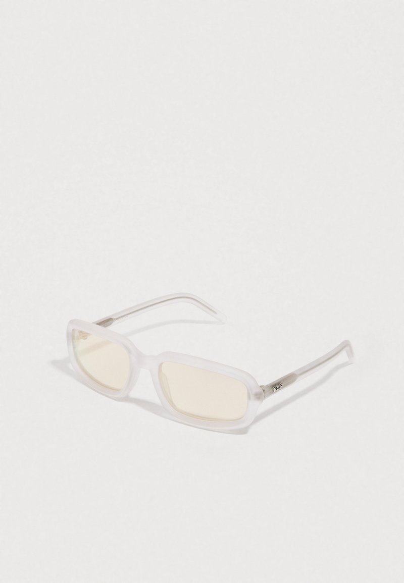 Läpinäkyvät kehysaurinkolasit, joissa on suorakulmaiset linssit, vaaleankeltainen sävy ja metalliset yksityiskohdat templeissa. Sileä pinta ja moderni muotoilu.