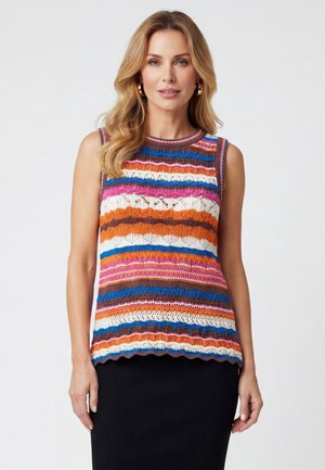 Donna che indossa un top a maglia multicolore senza maniche con righe orizzontali blu, arancioni, rosa, bianche e marroni, abbinato a una gonna nera.