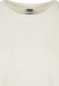 Weißer Baumwollpullover mit Rundhalsausschnitt und gerippten Bündchen. Hat ein Etikett mit der Aufschrift "Urban Classics", Größe XS. Glatte Textur.