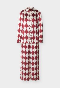 Ensemble chemise à manches longues boutonnée et pantalon à jambes larges à motif de losanges rouges et blancs avec des détails à volants sur le devant et aux poignets.