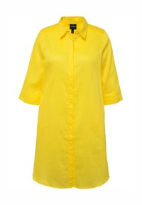 Abito camicia in lino giallo con collo a camicia, chiusura a bottoni frontale e maniche a tre quarti. Presenta una vestibilità rilassata e una texture liscia.
