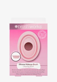 Bowl per la pulizia dei pennelli da trucco in silicone di colore rosa chiaro, forma ovale con interno testurizzato e impugnatura rialzata, confezionato con chiara marchiatura e indicatore per il viaggio.